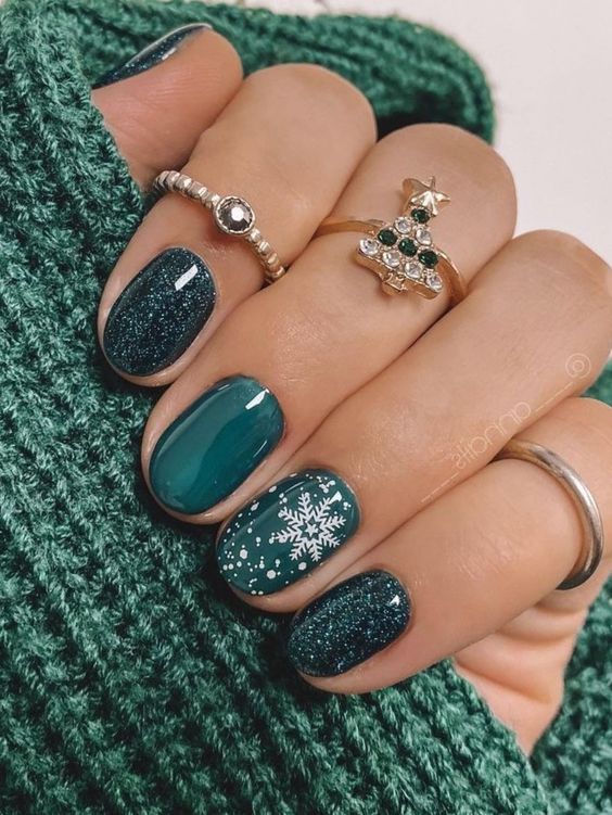 2. Festive Forest Green Nails with Glitter and Snowflake Designs
